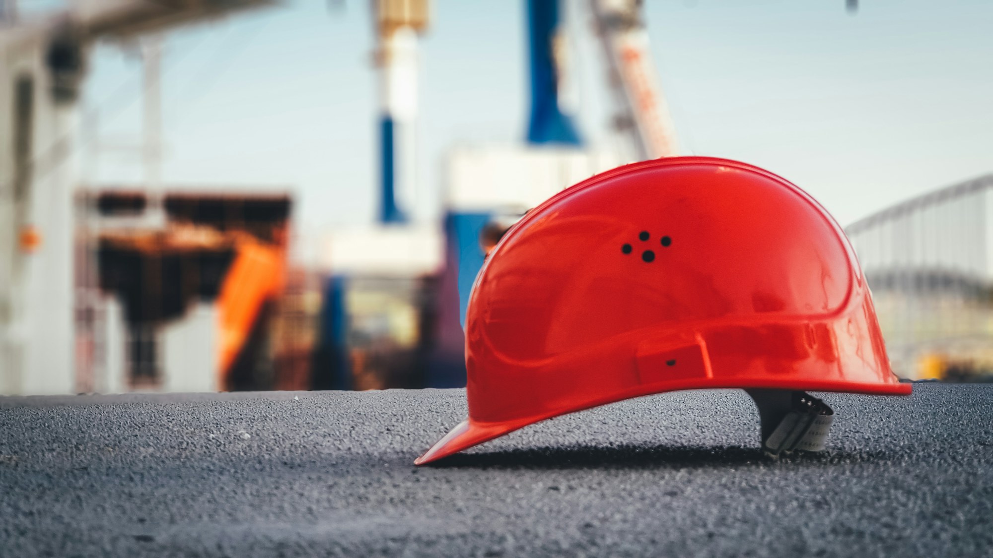 Chef de chantier consultant un plan technique sur tablette devant un chantier